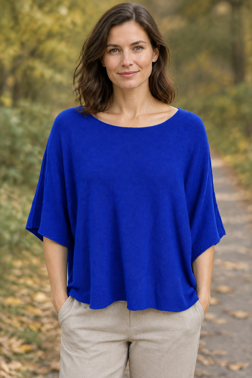 Blaues Strickoberteil am Modell auf einem Herbstweg