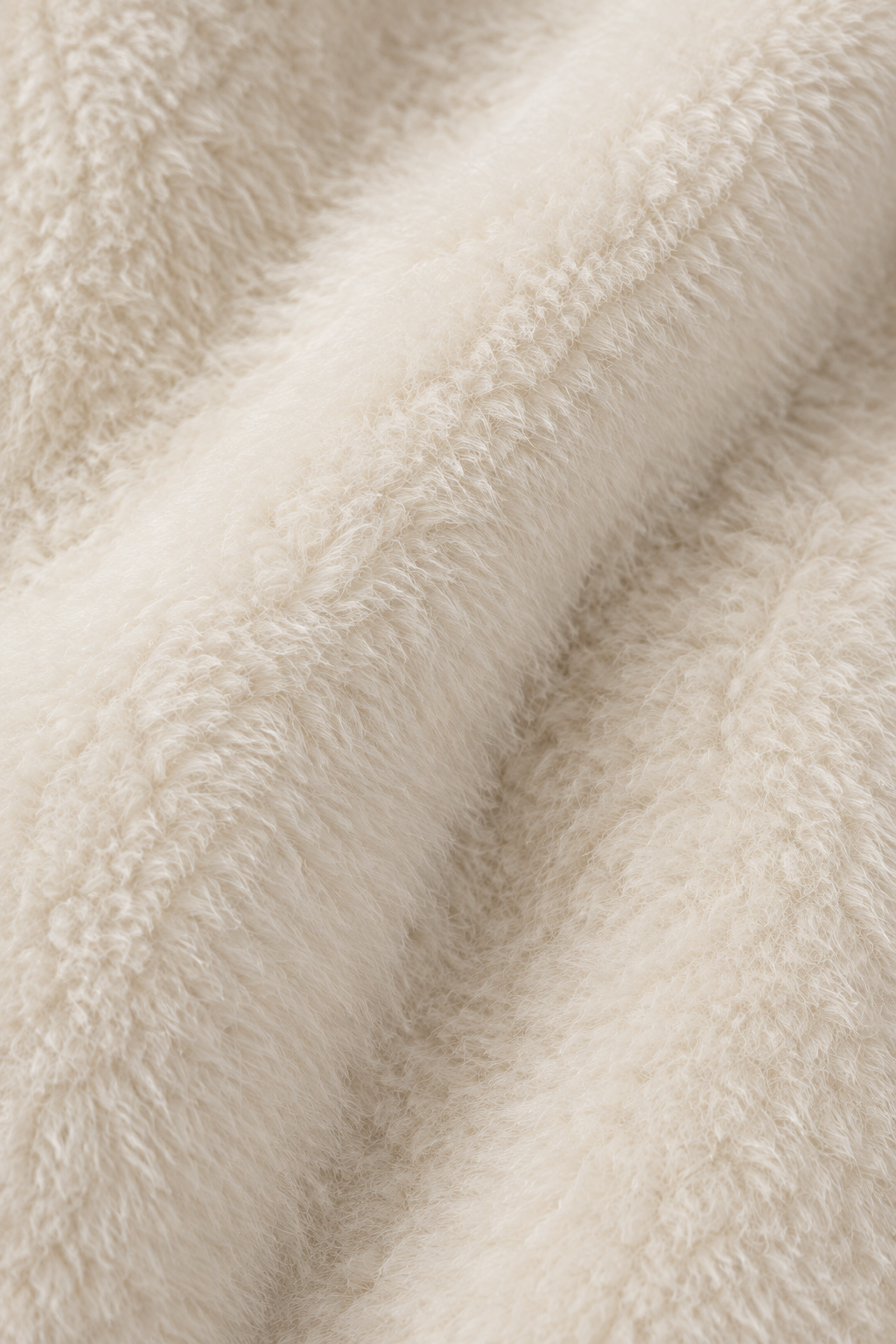 Nahaufnahme des cremeweißen Teddy-Obermaterials des Wintermantels