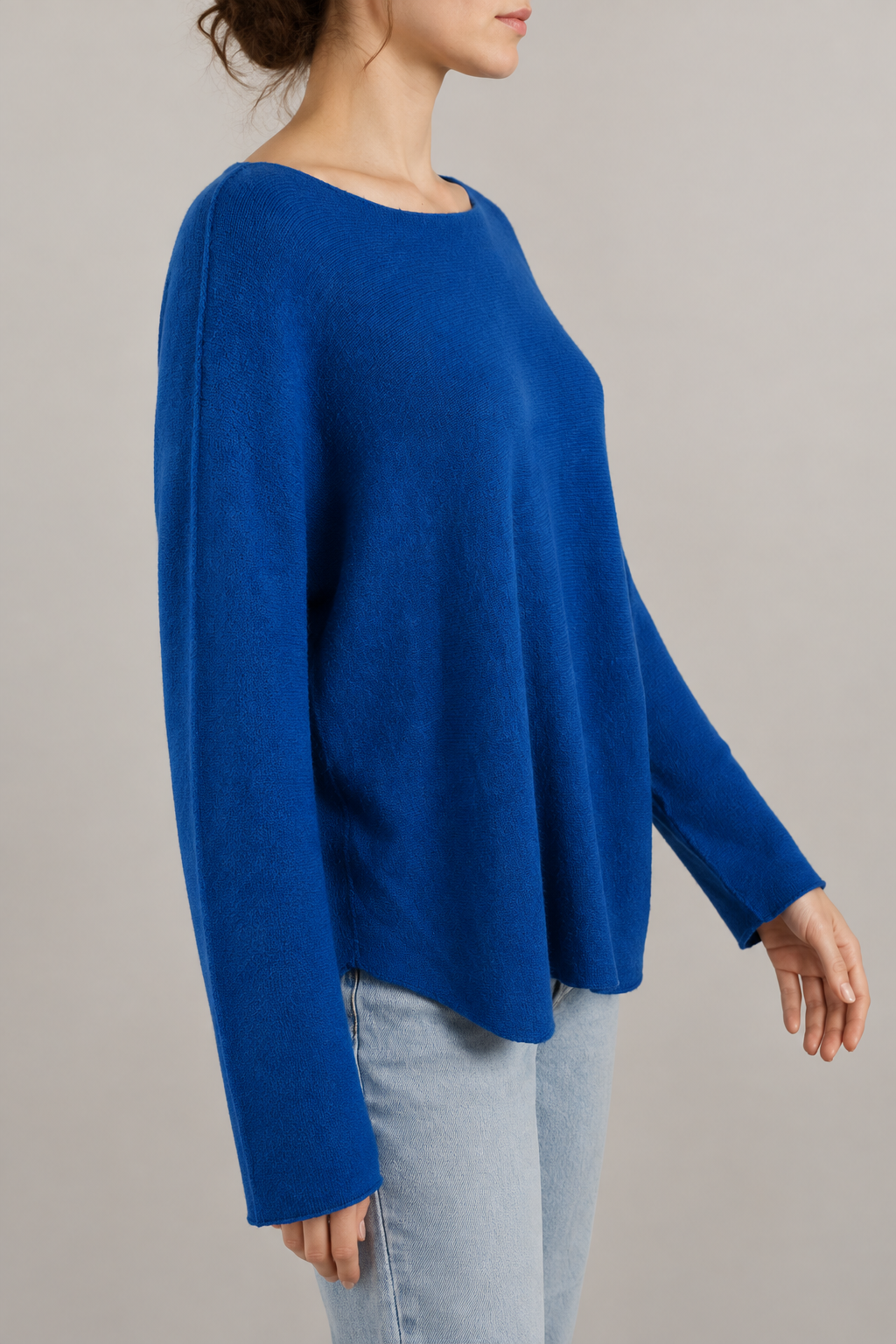 Blaues Langarm-Strickoberteil am Modell von der Seite mit längs verlaufender Ärmelnaht
