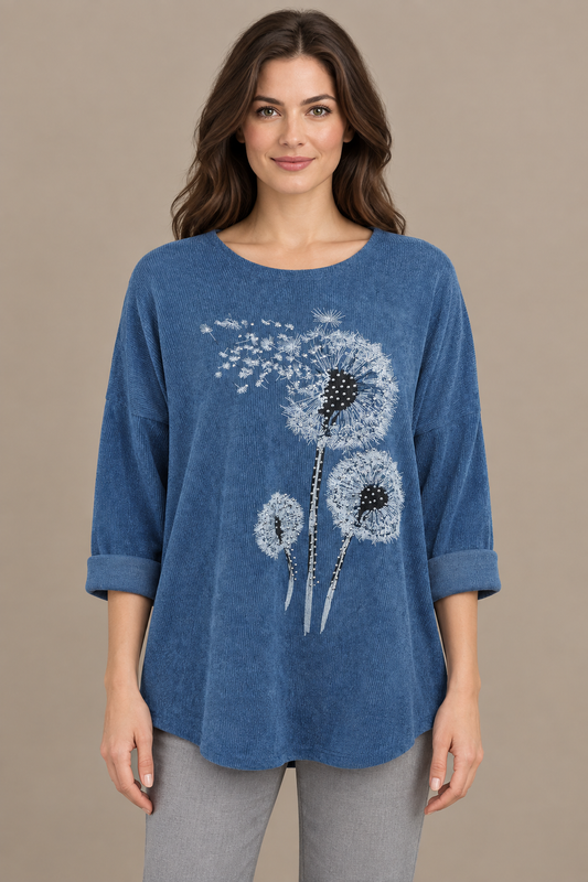 Blaues Damen-Oberteil mit Pusteblumenmotiv am Model vor greigem Hintergrund