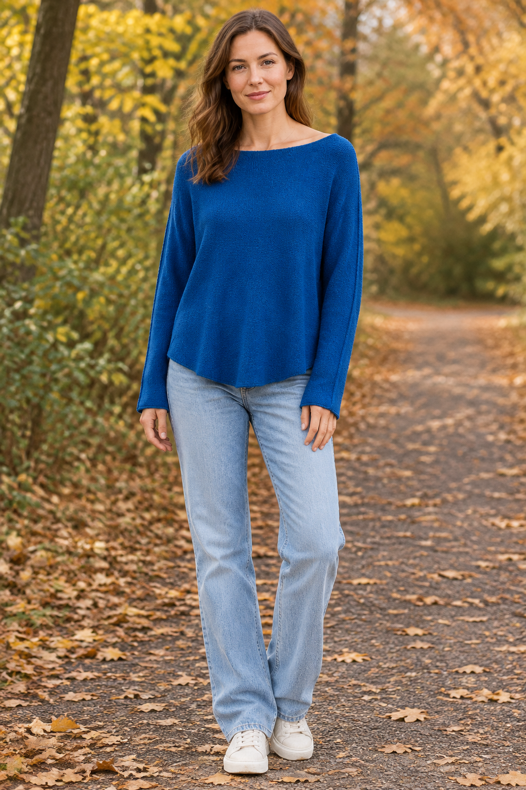 Blaues Langarm-Strickoberteil am stehenden Modell auf Herbstweg