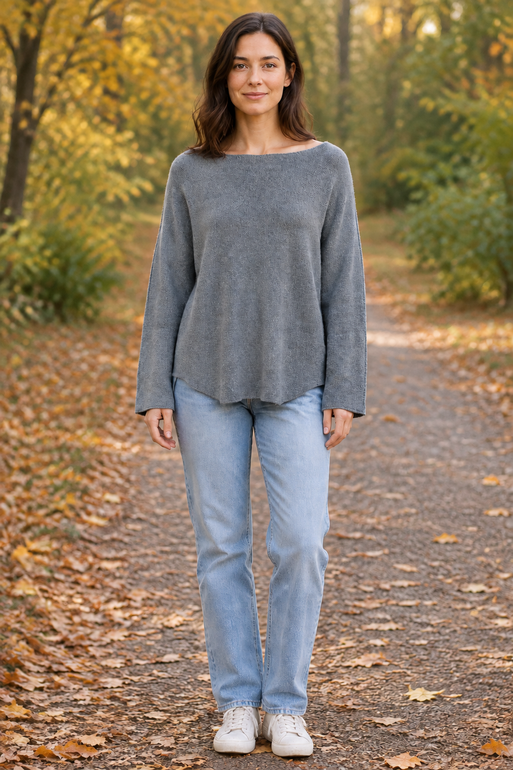 Graues Langarm-Strickoberteil am stehenden Modell auf Herbstweg