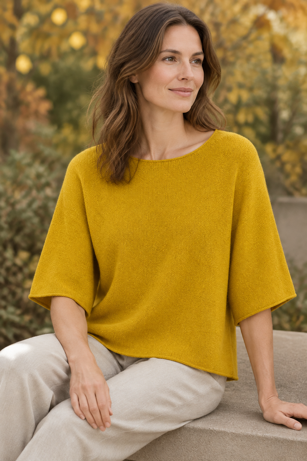 Gelbes Strickoberteil am sitzenden Modell