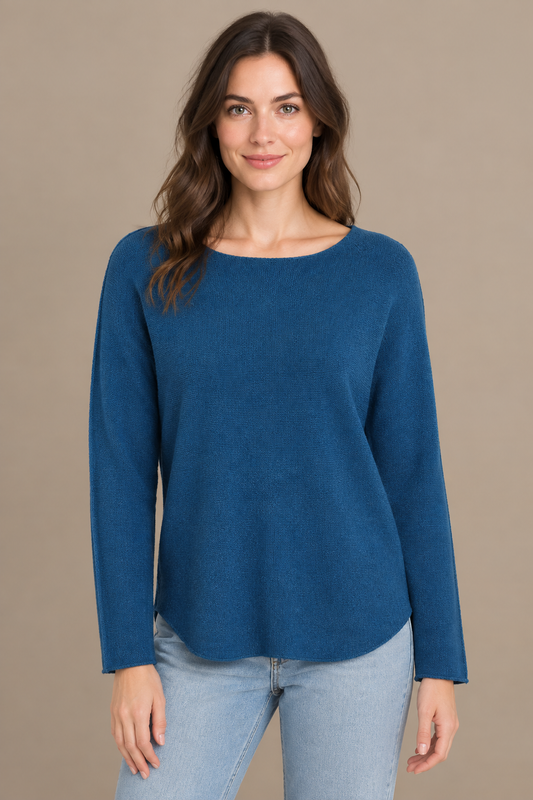 Denimblaues Langarm-Strickoberteil am Modell vorne vor warmem Greige-Hintergrund