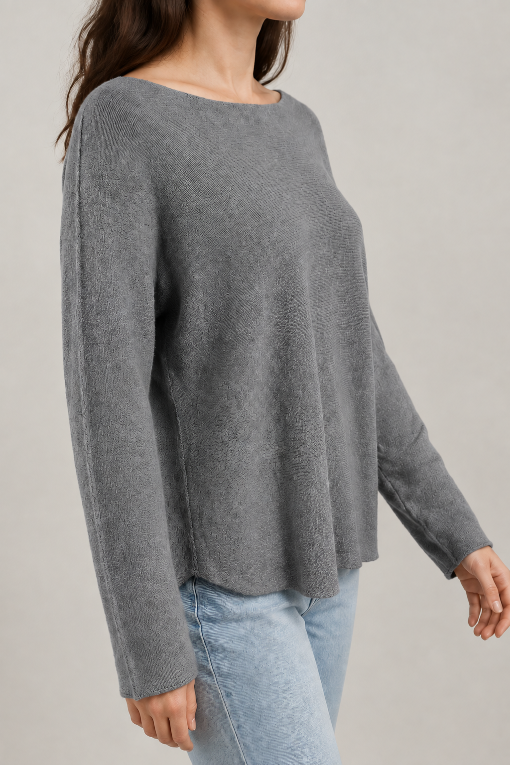 Graues Langarm-Strickoberteil am Modell von der Seite mit längs verlaufender Ärmelnaht