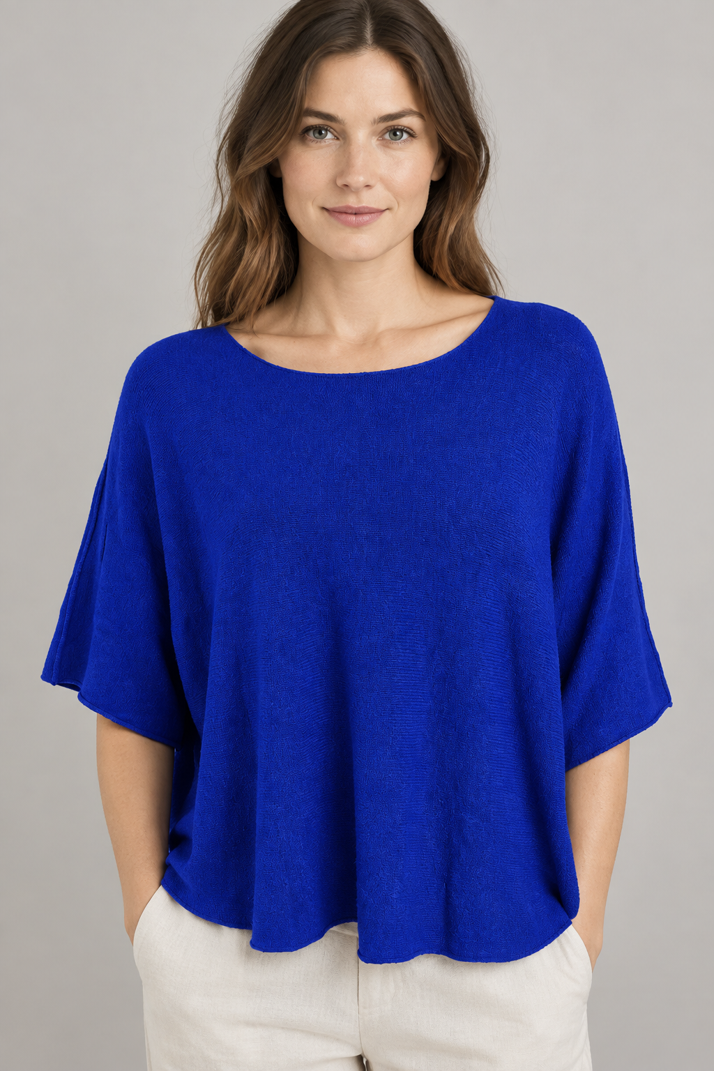 Locker fallendes blaues Strickoberteil am Modell von vorne