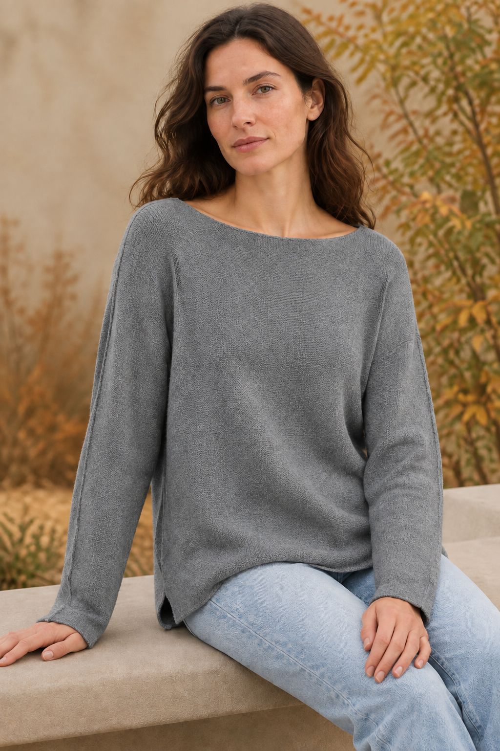 Graues Langarm-Strickoberteil am sitzenden Modell