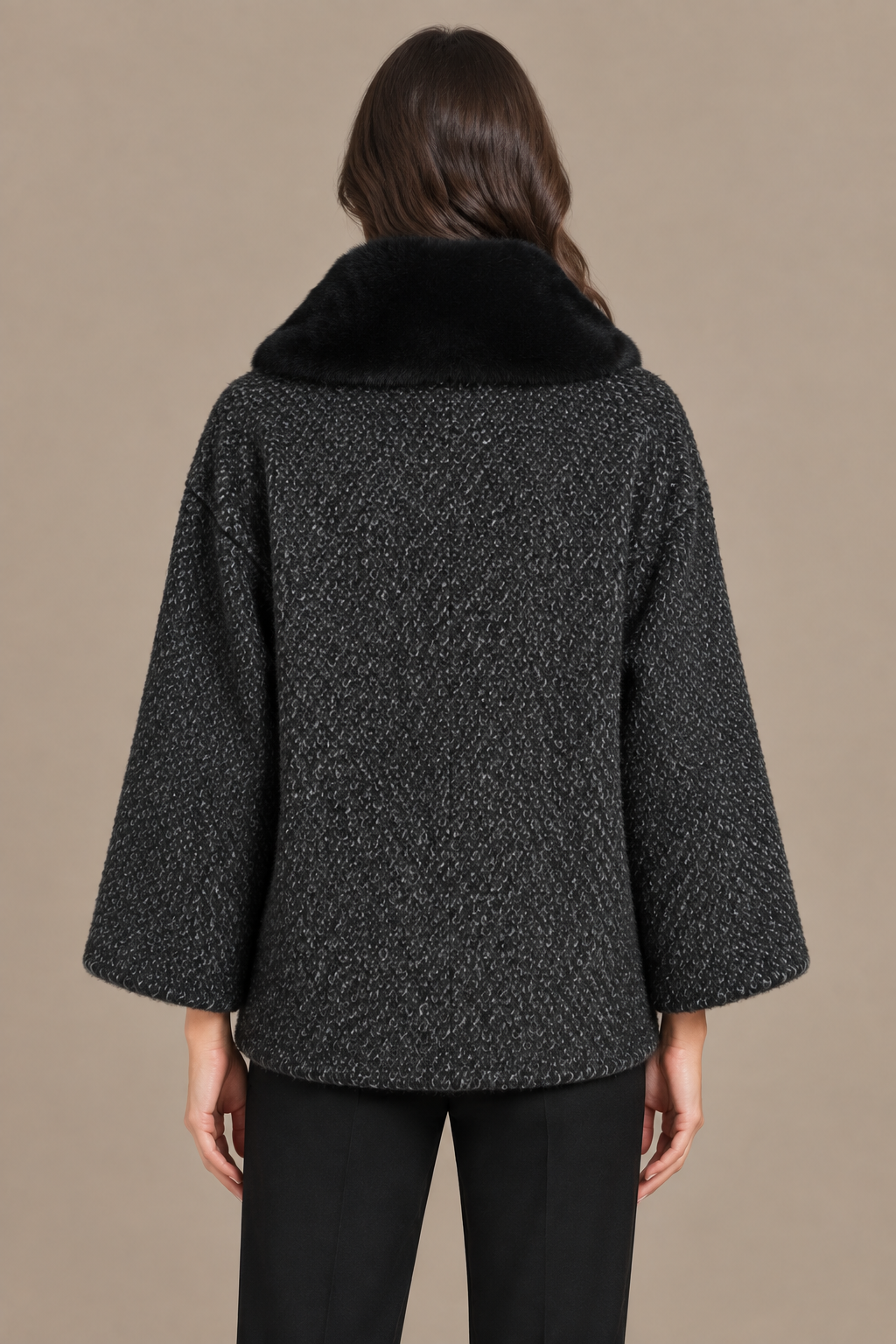 Dunkelgrauer Bouclé-Wintermantel mit schwarzem Fellkragen von hinten am Model